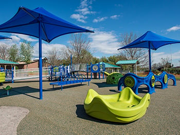 Numerous freestanding playground features showing inclusive design principles