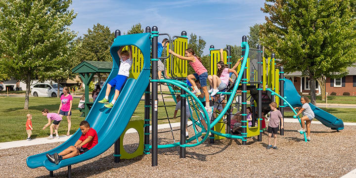 Kids playing in a teal blue playground structure featuring a net climber 
