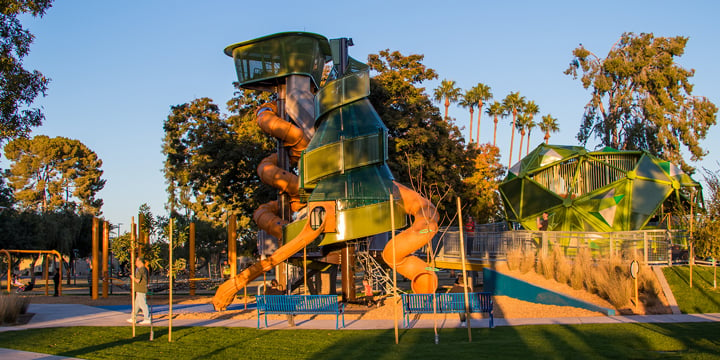 A full view of the three main playground structures shaped like local trees at Pioneer Park. 
