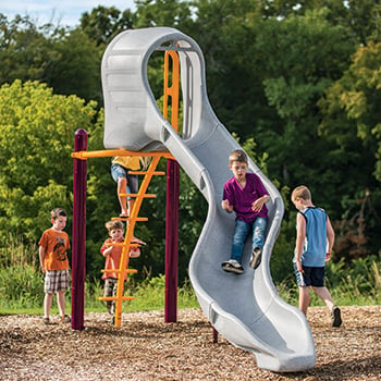 Children play on a twisty freestanding commercial slide for playgrounds