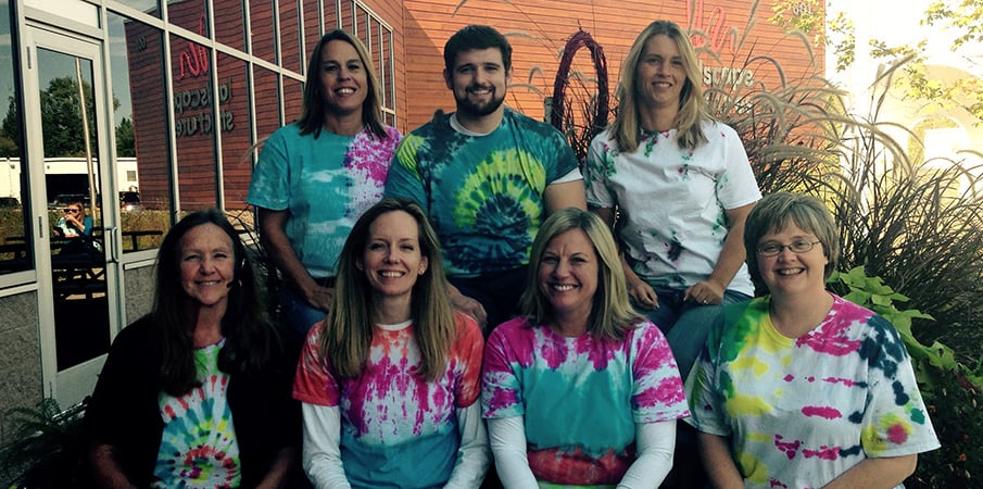 The human resource team at Landscape Structures pose for the camera while wearing home made tie dye t-shirts.