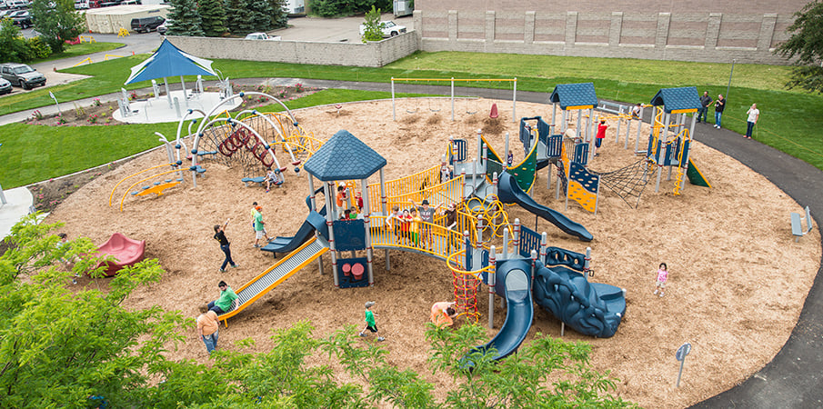 Elevated view of children playing on Evos and PlayBooster playground sets.
