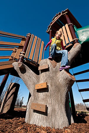 A girl climbs down a discovery tree climber.