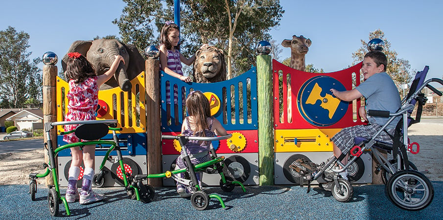 Three children play at sensory reach panels at an inclusive zoo themed playground.